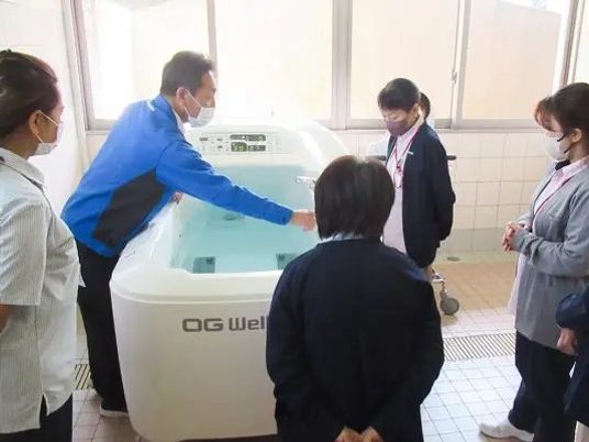機能訓練室で見学する職員  