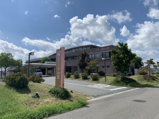 青空の下の建物外観 外観 緑に囲まれた施設の外観が特徴的です。青空の中、穏やかで落ち着いた雰囲気があります。
