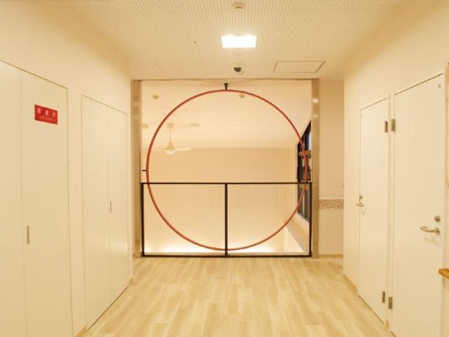 明るい廊下 廊下   木目調の床が広がる明るい廊下です。正面の円形デザインが印象的で、すっきりした動線に見えます。