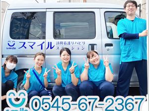 笑顔のスタッフと送迎車  