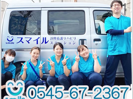笑顔のスタッフと送迎車  