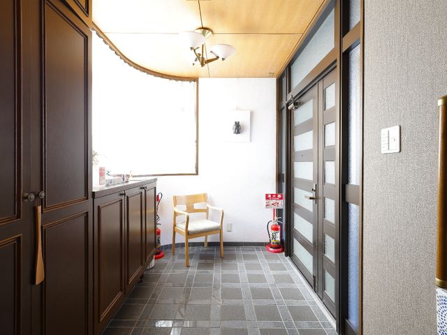 明るいエントランスと椅子 玄関 ゆったりとした椅子が配された開放的な入口です。待ち合わせや一息つく時間に適しています。