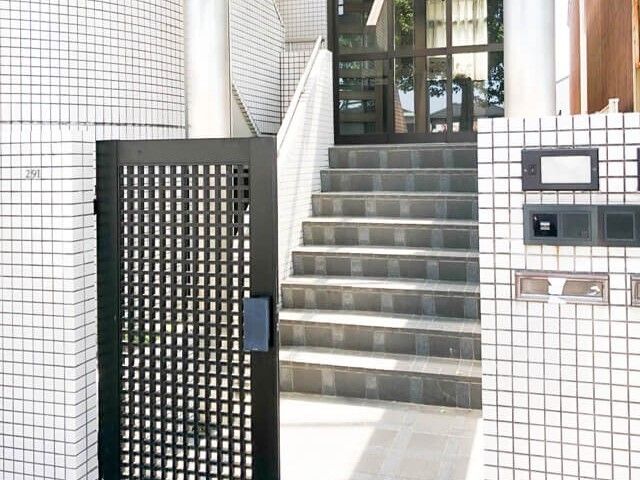 清潔感あるエントランス 玄関 モザイクタイルが印象的な入口は、来訪者を迎える顔として清潔感があります。開放的な造りで、明るく温かみのある歓迎空間が広がっています。