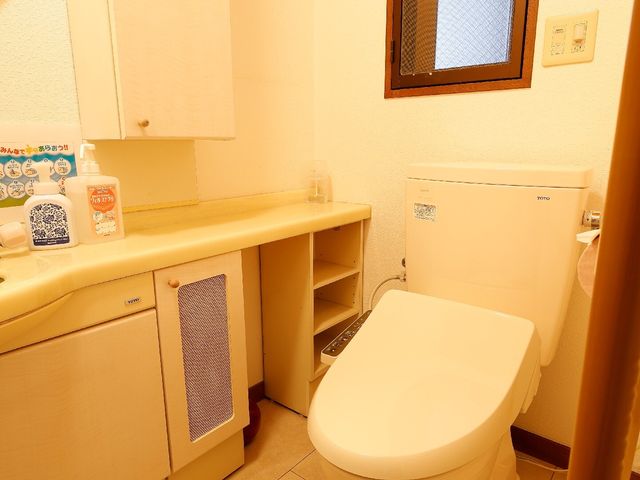 清潔な洋式トイレ空間 トイレ 手すりが設置されたバリアフリーのトイレです。清潔感があり、利用者の安全と快適さを考慮しています。
