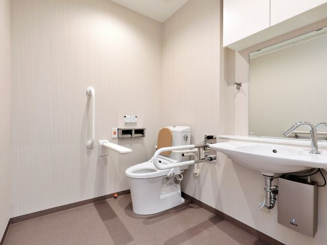 バリアフリーの洗面台とトイレ トイレ 手すり付きの安全なトイレです。床も滑りにくい素材を使用しており、心地よい利用ができます。