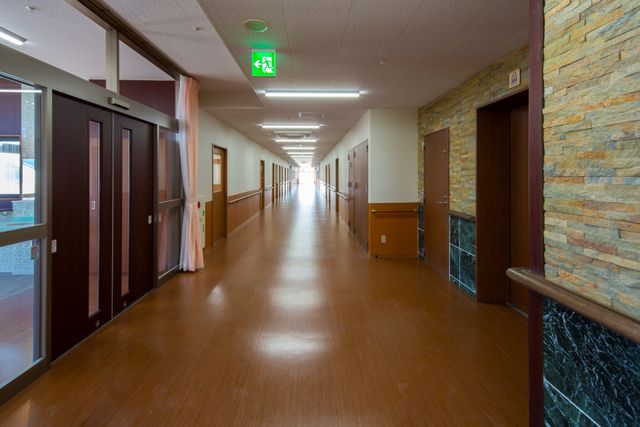 廊下の明るい風景 環境 ゆったりとした廊下は清潔感があり、安らぎを提供する設計です。人々の行き交う姿は、活動的な日常を物語っています。