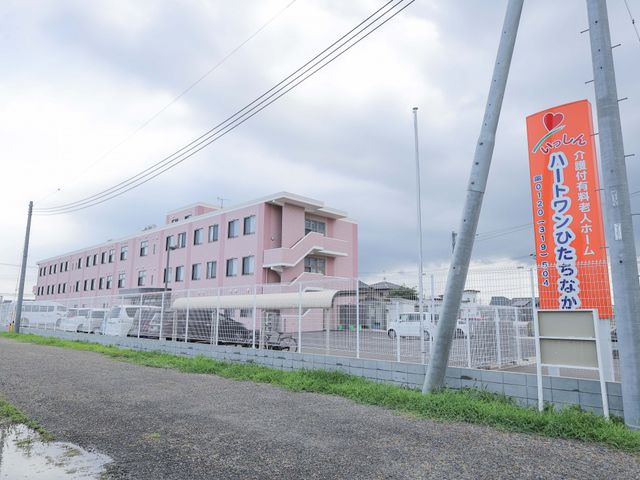ピンク色の建物の外観 外観 広々としたピンク色の建物の前には、安心を感じさせる柔らかな色合いの看板が設置されております。