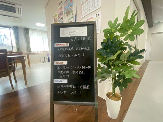 メニュー看板と植木のそば