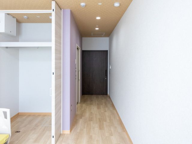 明るい居室の一角 居室 ゆったりとした空間が確保された居室です。木目調の床が温かみを感じさせ、明るい日差しが差し込む落ち着いた雰囲気のお部屋となっています。
