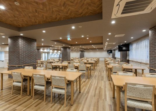 木目調のテーブルと椅子の配置された広いスペース