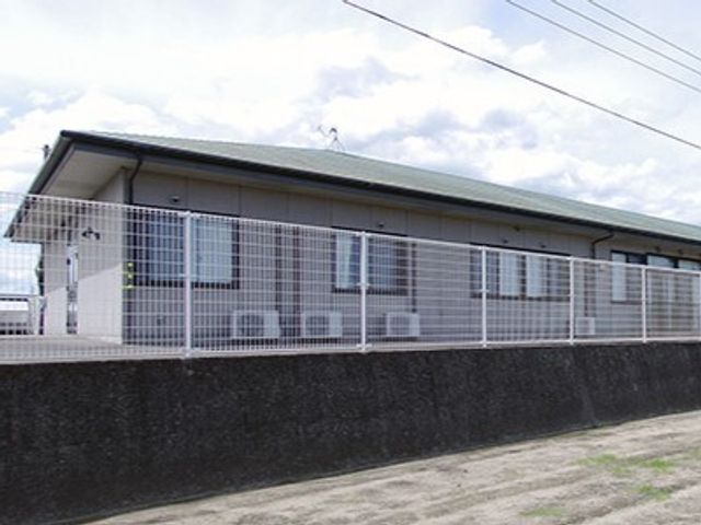 施設の外からの景色 外観 柔らかな光を受けた穏やかな建物です。周囲は静かで、落ち着いた環境が広がっています。