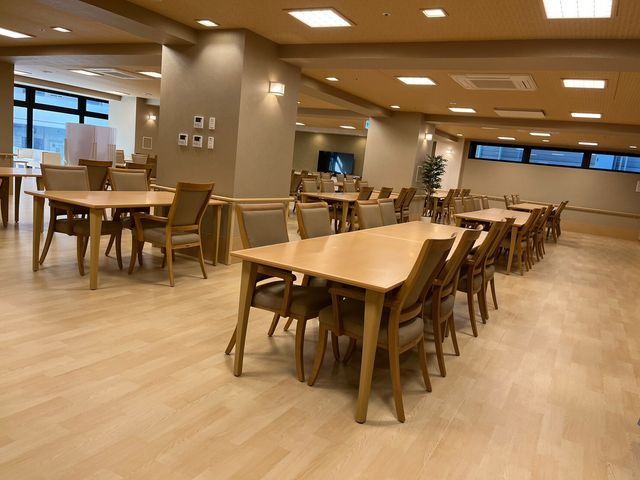 広々とした食堂の空間 食堂 ゆったりとした木のテーブルと椅子が配置された食堂です。日の光が差し込む明るい空間で、ゆっくりとした時間を過ごせる場所となっています。