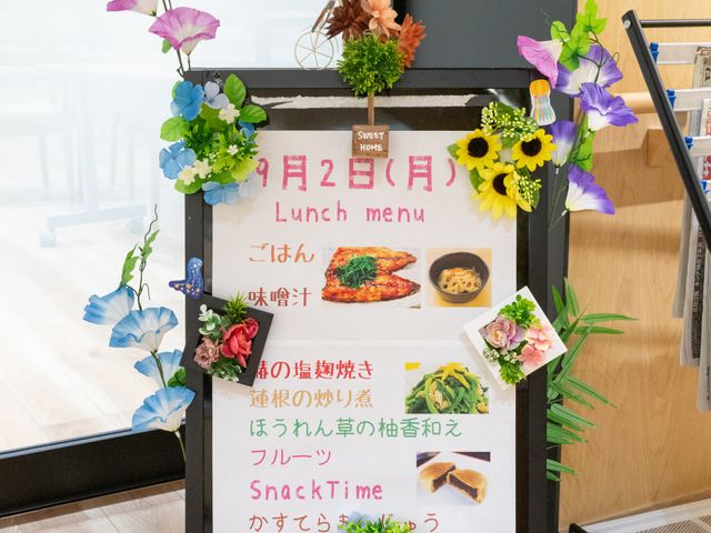 食堂メニュー案内掲示 食堂 色とりどりの花に囲まれたメニュー案内です。健康的な食事と楽しいひと時をお約束します。
