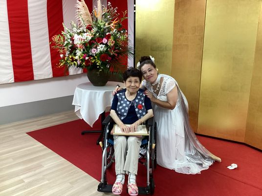 笑顔の女性二人と車椅子、室内