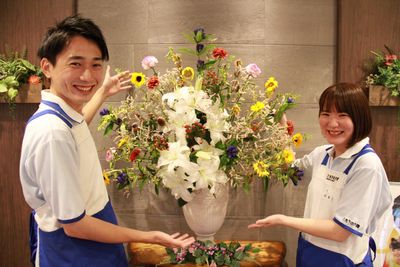 笑顔のスタッフと花飾りの展示