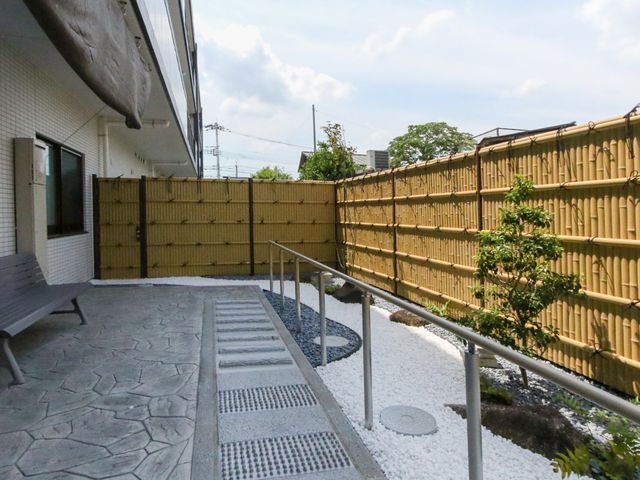 中庭の歩道とベンチ 庭 ゆったりとしたベンチがある中庭です。自然光が降り注ぎ、心安らぐひとときを過ごせます。