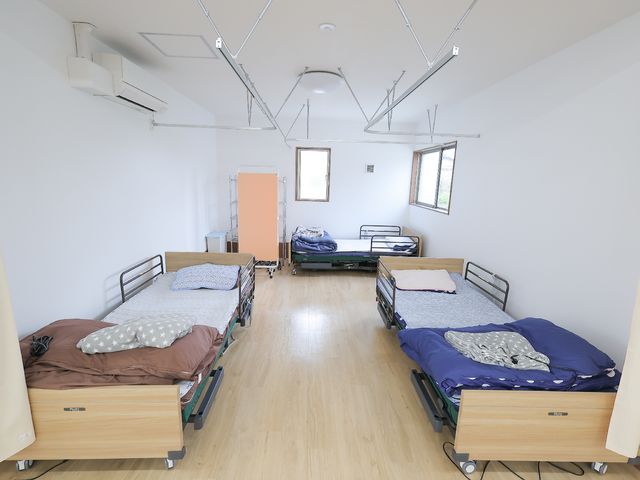 明るい共同居室 居室 広々として清潔感のある居室です。利用者の快適な生活サポートを行うための環境が整っています。