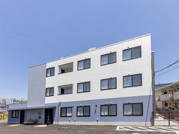 白い壁の建物と駐車場