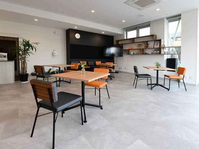 広々とした施設の食堂 ケア 広々とした空間の食堂は、落ち着いた色合いでまとめられ明るい雰囲気です。交流や食事を楽しむ場として最適な環境が整っています。