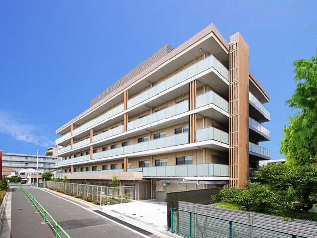 外観の建物正面 外観 青空に映える、バルコニーが並ぶ落ち着いた外観です。周囲に緑もあり、明るい雰囲気が伝わります。