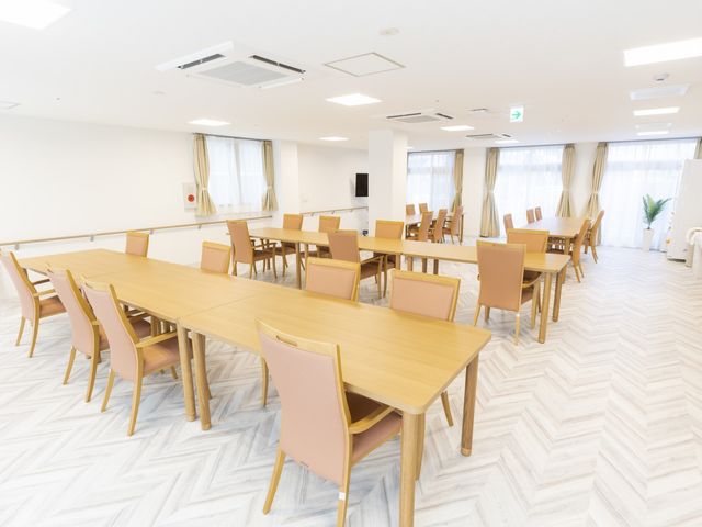 広々とした明るい食堂 食堂 ゆったりした木製のテーブルと椅子が配置された明るいダイニングスペースです。窓からの自然光が心地よい環境を作り出しています。