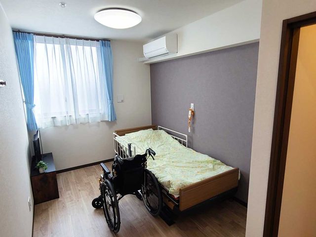 車椅子付きの快適な居室 居室 広々として快適な個室で、ベッド横には移動が便利な車椅子が置かれており、安心して日々を過ごせるよう配慮されています。