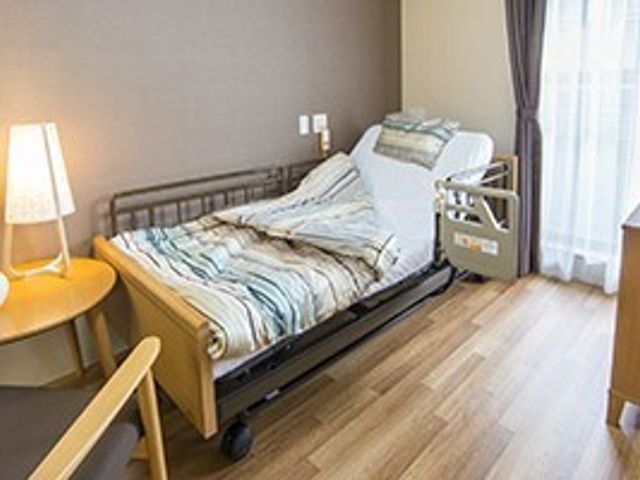 居心地の良い居室 居室 温かみのある照明と木目調の家具が印象的な居室です。快適な生活空間を提供しており、ゆったりとお過ごしいただけます。