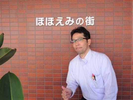 笑顔のスタッフ看板前
