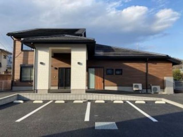 新しい建物と駐車場 外観 木目調の外壁が特徴的で、快適な空間を提供しています。駐車場も広く、アクセスが便利です。