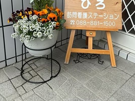 看板と花のある玄関前  