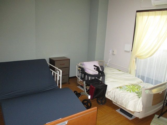 居室のベッドと車椅子 夫婦部屋 ゆとりのある個室で、快適な休息が取れる環境が整っています。お一人お一人のプライバシーを尊重した空間です。