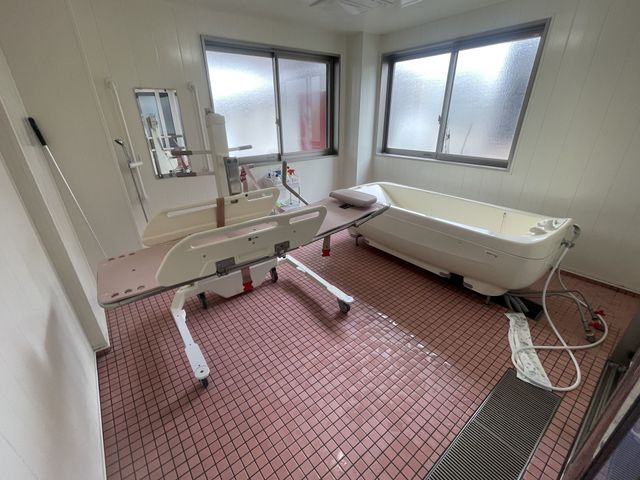 介助浴槽のある風景 浴室 利用者が安心して入浴できる広々としたバリアフリー設計です。自然光で明るく清潔感があります。