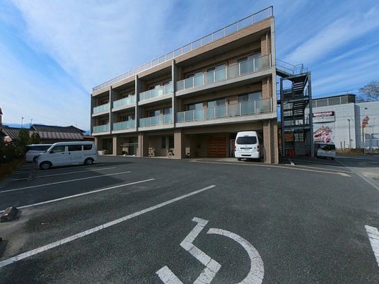 広い駐車スペースの建物外観