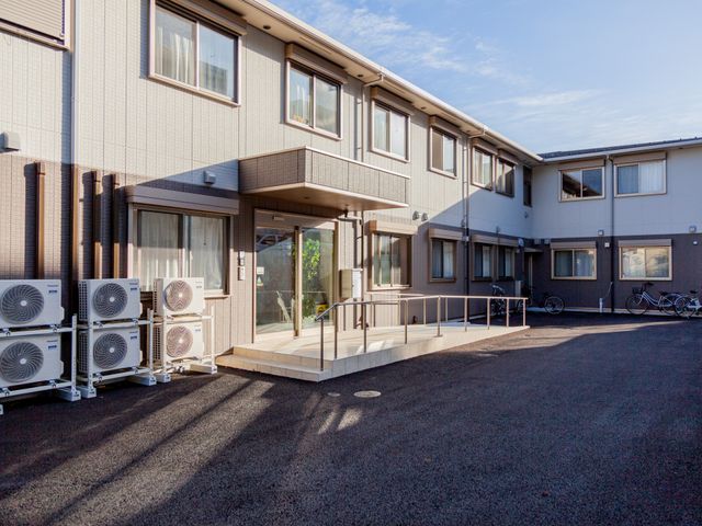 清潔な施設のエントランス 外観 モダンなデザインのエントランスが迎える、快適な職場環境をご提供します。入り口はバリアフリー設計で、アクセスも容易です。