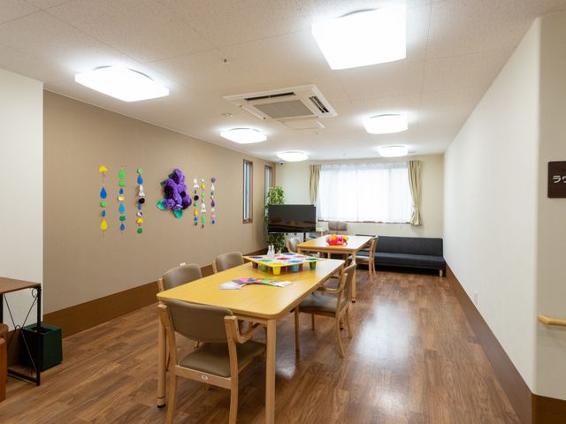 温かみのある共有スペース 共有スペース ゆったりとしたソファとテーブルが設けられた共有スペースです。壁には色鮮やかな装飾があり、くつろぎの時間を提供しています。