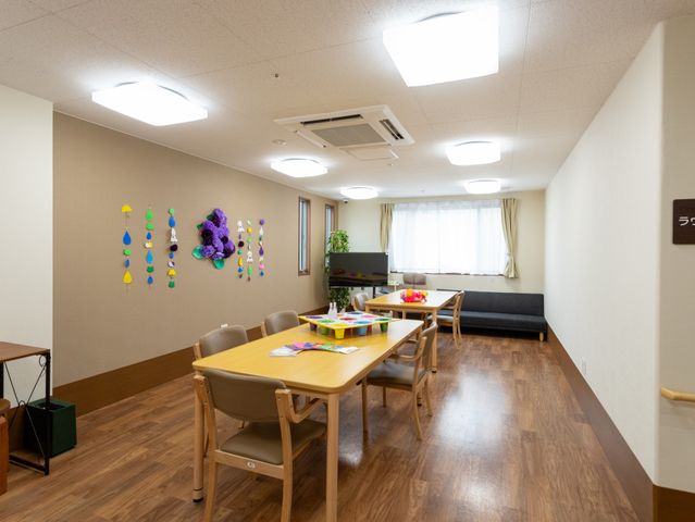 温かみのある共有スペース 共有スペース ゆったりとしたソファとテーブルが設けられた共有スペースです。壁には色鮮やかな装飾があり、くつろぎの時間を提供しています。