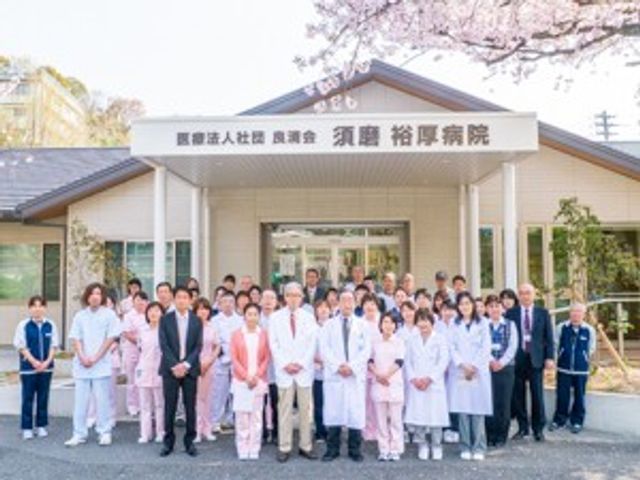 スタッフ集合の施設外観 外観   桜の下に建つ落ち着いた外観です。白衣のスタッフが並んでおり、働く人の雰囲気が伝わります。