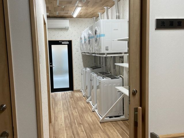 清潔感ある洗濯室 ランドリー 広々とした洗濯室には、複数の洗濯機や乾燥機が整然と並び、快適な利用環境が整っています。