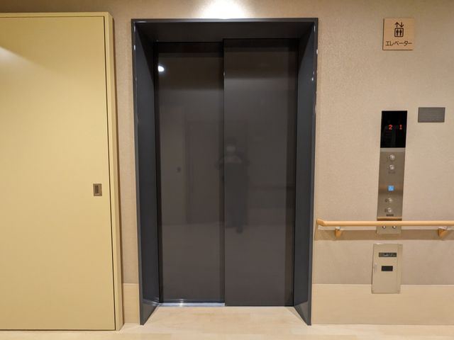 清潔感のあるエレベーター前 内観 手すりが設置されたエレベーター前は、バリアフリー設計になっており、どなたでも安心してご利用いただけます。