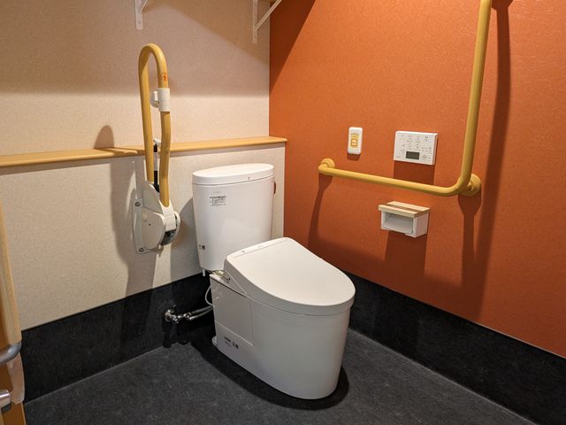 バリアフリートイレ トイレ 手すり付きで安全を考慮したトイレ空間です。清潔感があり、利用者のニーズに対応できる設計になっています。