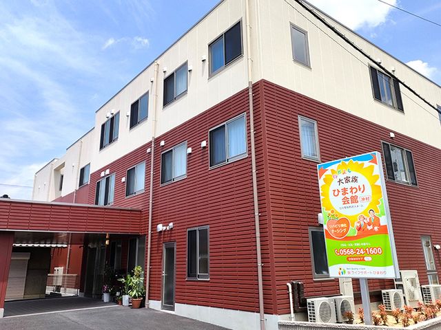 看板と建物の外観 外観 広々とした建物の前に、明るい看板が目立ちます。青空と融合した清潔感ある雰囲気です。