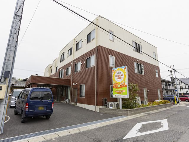 褐色の建物の外観 外観 落ち着いたデザインの建物は、木目調の外壁が特徴です。周囲には植栽が配置されています。