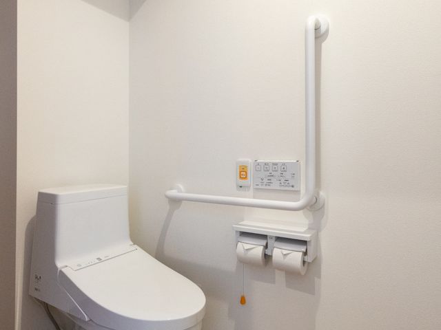 安全設計のトイレ トイレ 手すりが設置された安全なトイレです。利用者の方が安心して使えるよう工夫されています。