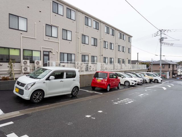 駐車場のある建物 外観 広々とした駐車スペースが完備されていますので、車での通勤も安心です。施設の外観はモダンなデザインです。