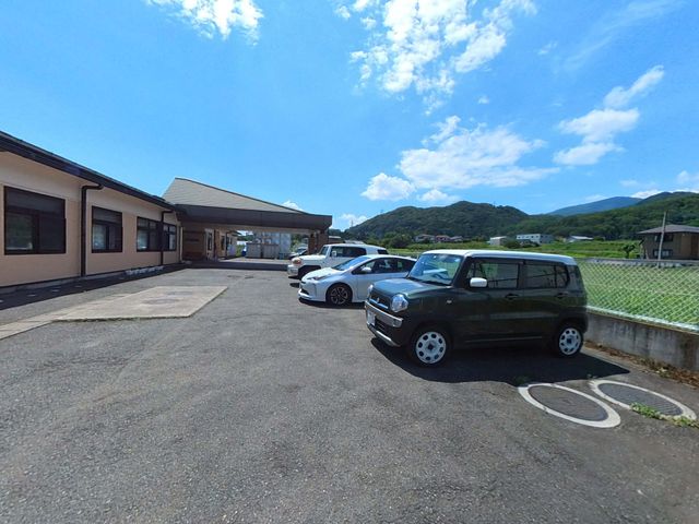 広々とした施設の外観 駐車場 自然に囲まれた施設外観です。青空の下、清潔感のあるエントランスが皆様をお迎えします。