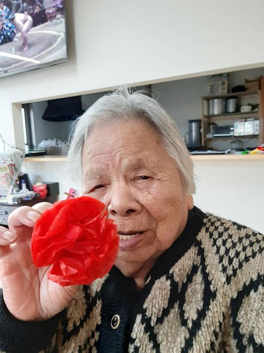お祝いの品を手にする利用者