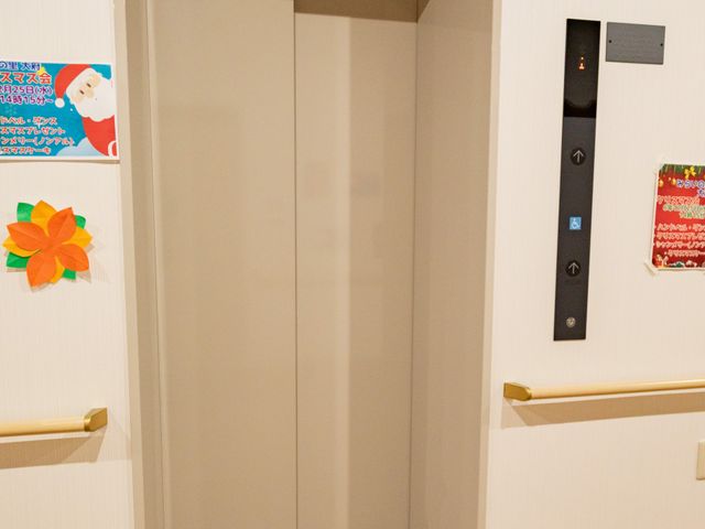 安全で快適なエレベーター エレベーター エレベーターは広々としており、車椅子の利用者にも安心な設計です。ポスターで季節感も演出されています。