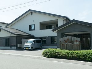 白い建物と送迎車の外観