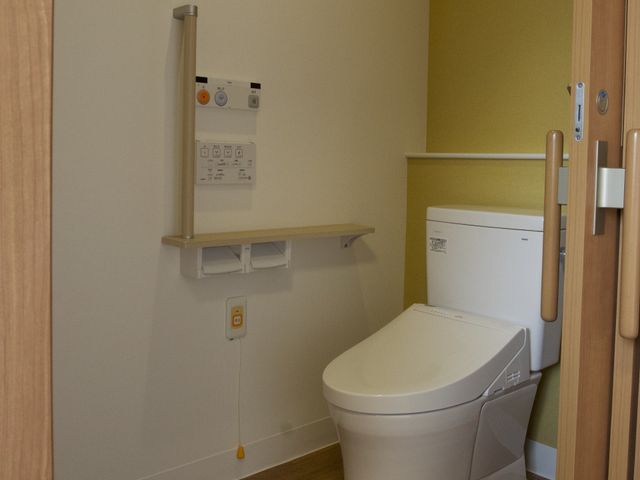 バリアフリー対応トイレ トイレ 安全に配慮された設計のトイレスペースです。手すりや緊急呼出し装置があり、心強いサポートが提供されています。