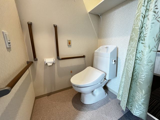 手すり付きトイレ トイレ 広いスペースを持つトイレには、手すりが設置されており、安心して利用できます。